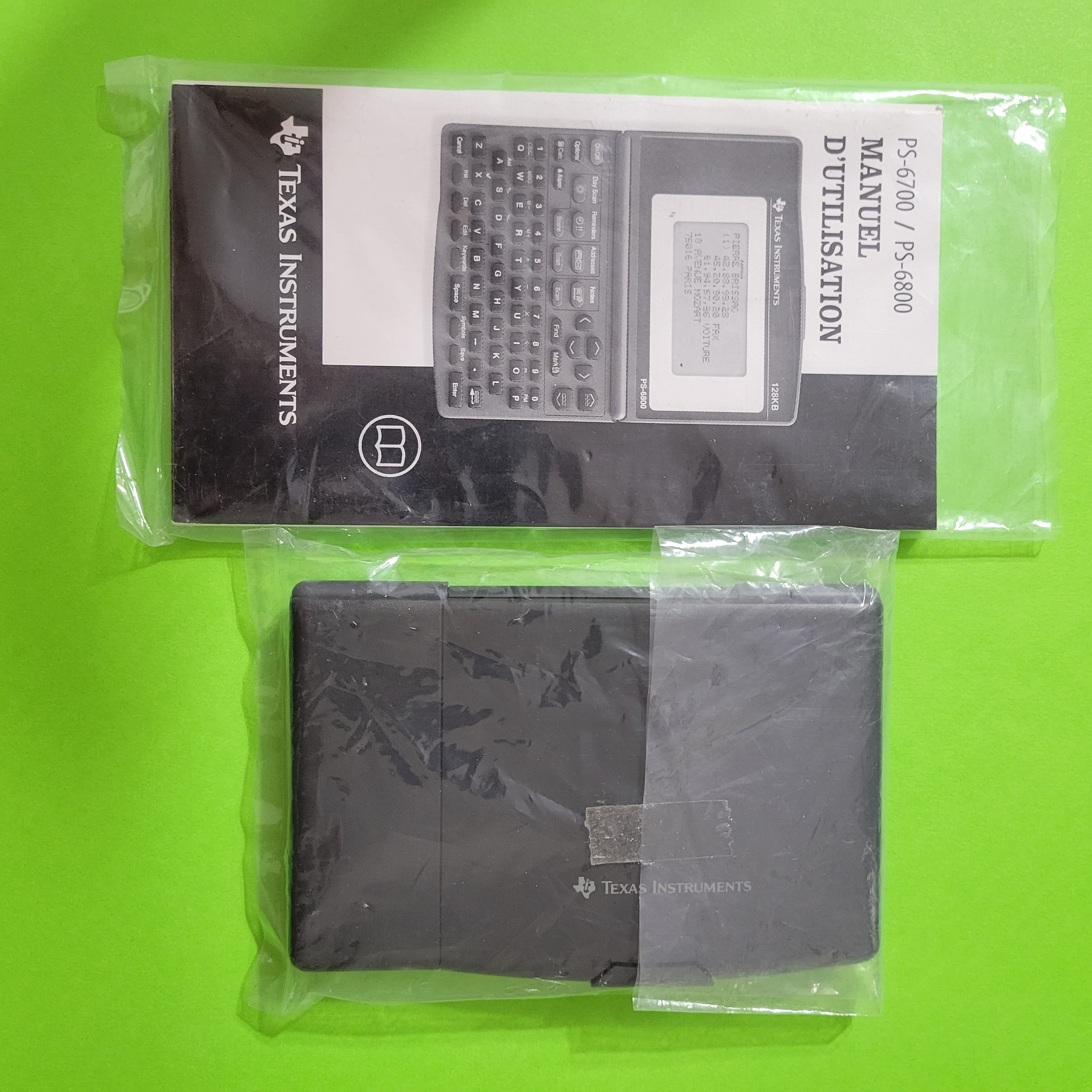 An image of the manuals and Texas Instruments PS-6700 personal organizer in their original plastic bags